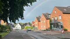 Straße mit Regenbogen am Himmel